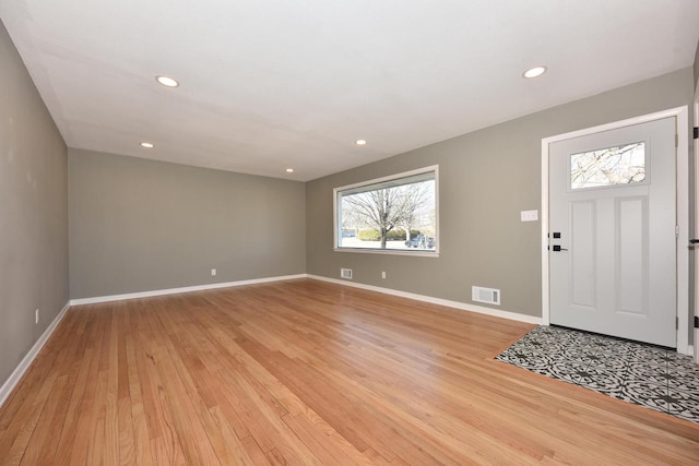 entryway featuring baseboards, visible vents, and light wood finished floors