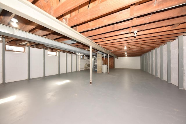 unfinished basement with water heater and concrete block wall