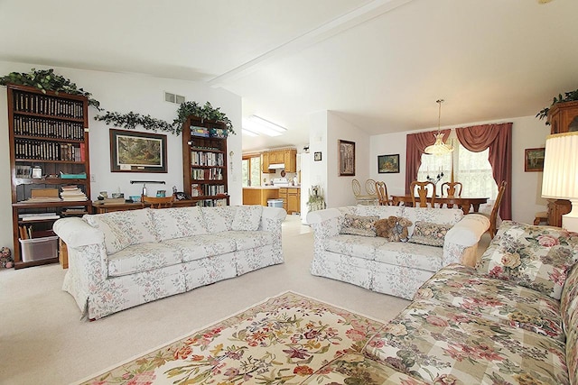 living area with lofted ceiling with beams, visible vents, and light colored carpet