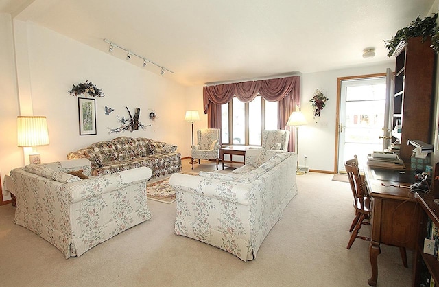 living area featuring baseboards, carpet, and track lighting