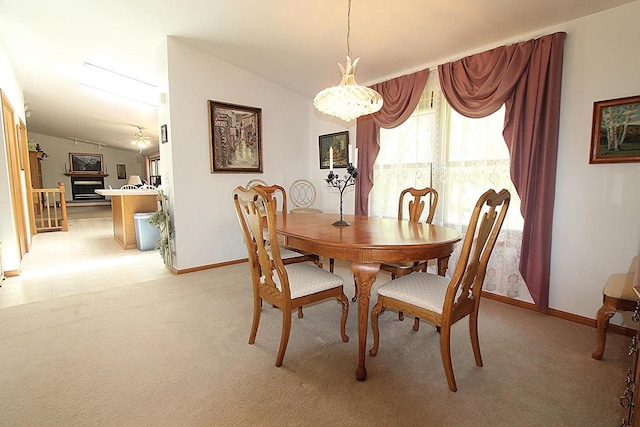 dining area with lofted ceiling, ceiling fan, light carpet, and baseboards