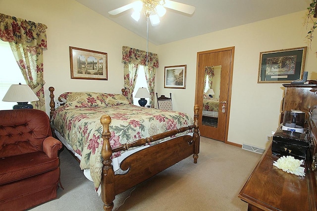 bedroom featuring baseboards, visible vents, light colored carpet, ceiling fan, and vaulted ceiling