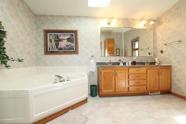 bathroom featuring double vanity, wallpapered walls, a sink, baseboards, and a bath