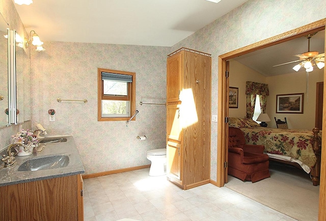 ensuite bathroom featuring ensuite bath, a sink, toilet, and wallpapered walls