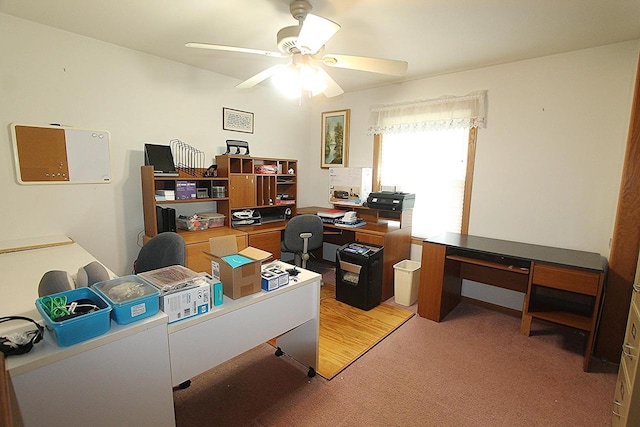 carpeted office space featuring a ceiling fan