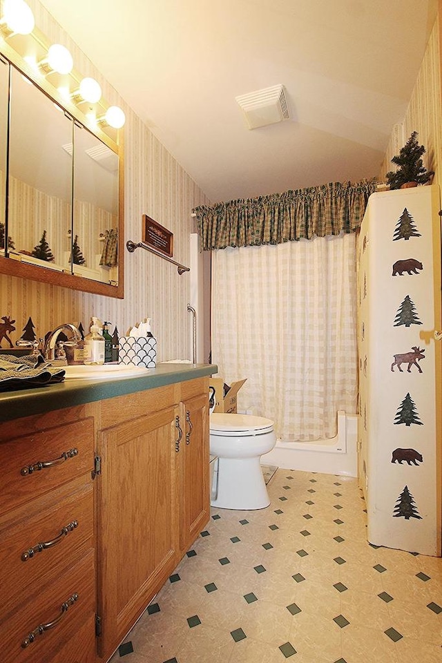 full bathroom featuring toilet, visible vents, vanity, a shower with curtain, and wallpapered walls