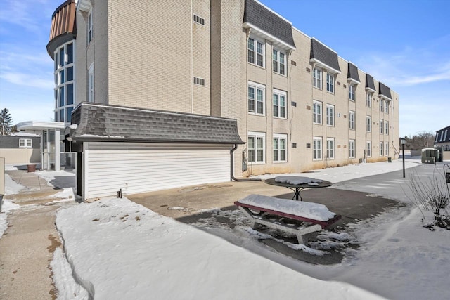 snow covered building featuring cooling unit