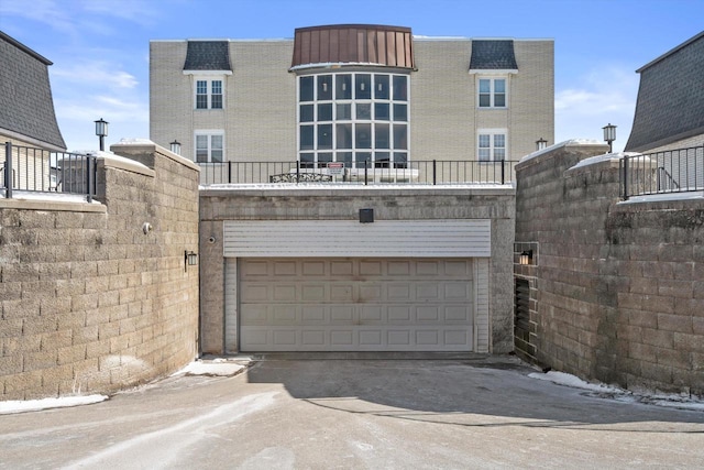 view of front facade featuring a garage, fence, and concrete driveway