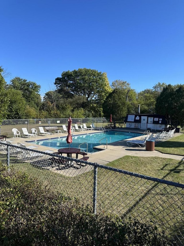 community pool with a patio and fence