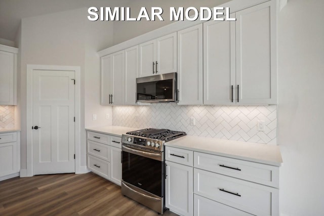 kitchen with dark wood finished floors, light countertops, backsplash, appliances with stainless steel finishes, and white cabinets