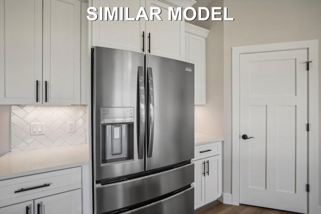 kitchen with light countertops, backsplash, white cabinetry, and stainless steel fridge with ice dispenser