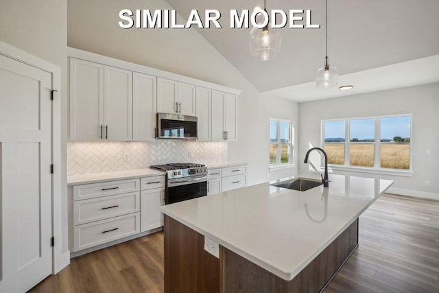 kitchen featuring tasteful backsplash, dark wood finished floors, stainless steel appliances, white cabinetry, and a sink