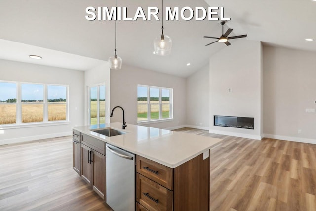 kitchen with dishwasher, a glass covered fireplace, open floor plan, and a sink