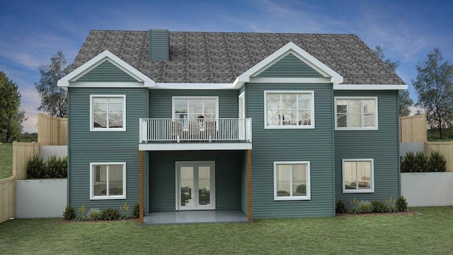 back of property at dusk featuring french doors, a shingled roof, a lawn, fence, and a balcony