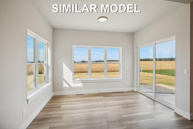 unfurnished sunroom with a rural view, visible vents, and a healthy amount of sunlight