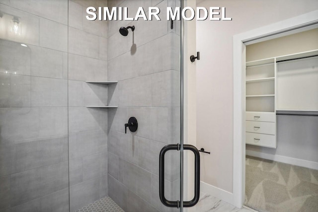 bathroom featuring a stall shower, marble finish floor, and baseboards