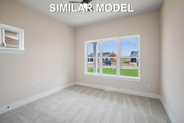 carpeted spare room with visible vents and baseboards