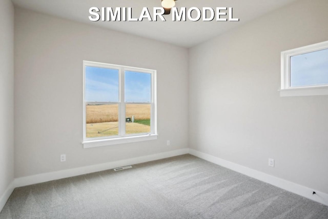 carpeted empty room featuring visible vents and baseboards