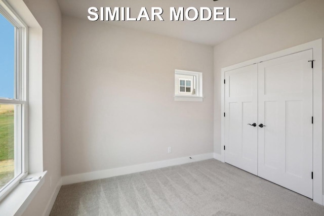 unfurnished bedroom featuring a closet, carpet flooring, and baseboards