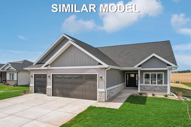 craftsman-style home with concrete driveway, an attached garage, board and batten siding, stone siding, and a front lawn