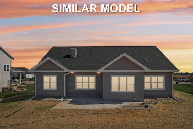 500 Whitford Ave, Prairie Du Sac, WI 53578 - back of property at dusk featuring a patio, a yard, and a shingled roof
