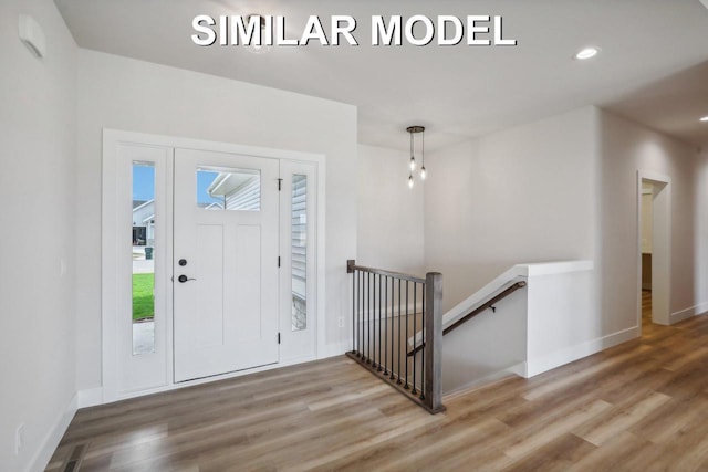 foyer entrance featuring visible vents, baseboards, wood finished floors, and recessed lighting