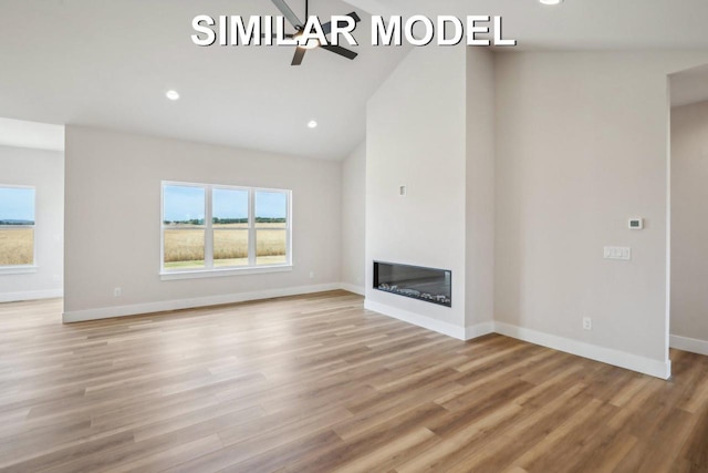 unfurnished living room featuring light wood-style flooring, baseboards, a ceiling fan, and a glass covered fireplace