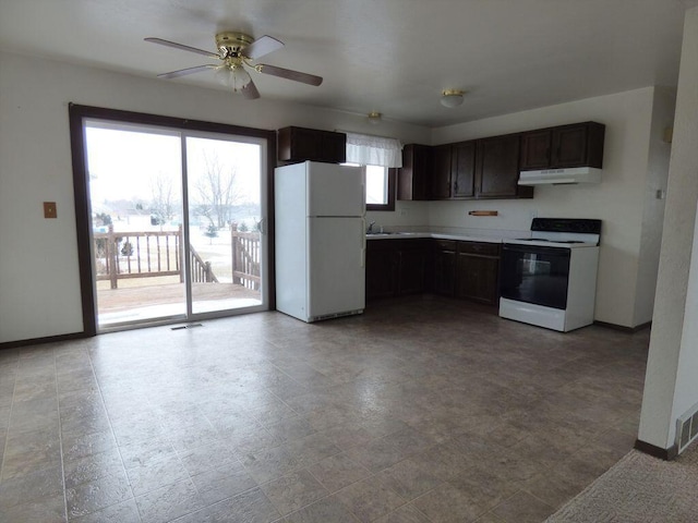 kitchen featuring baseboards, visible vents, freestanding refrigerator, under cabinet range hood, and range with electric stovetop