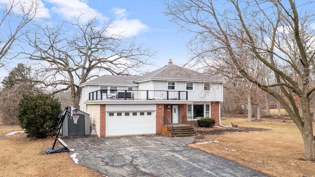 traditional-style home featuring a balcony, driveway, a garage, and brick siding