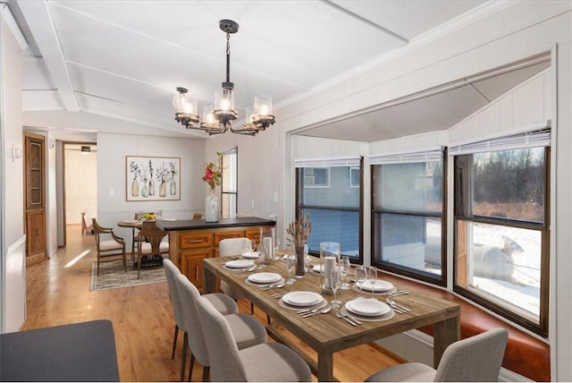 dining space featuring light wood-type flooring, lofted ceiling with beams, and a chandelier