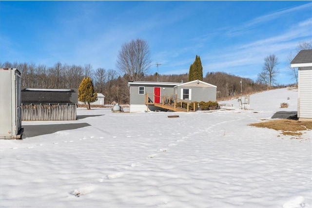 yard layered in snow featuring an outdoor structure and a wooden deck