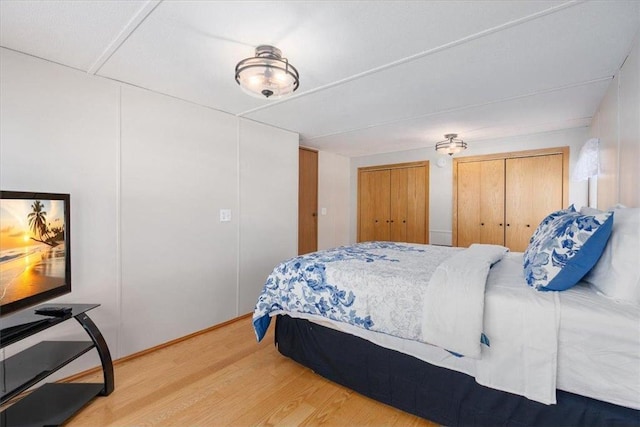 bedroom with two closets and wood finished floors