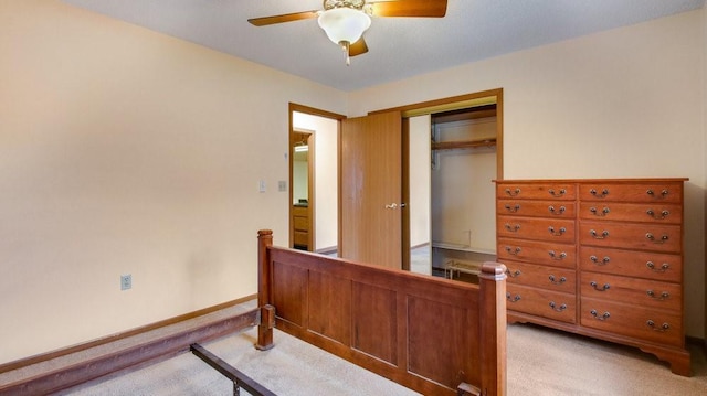 bedroom featuring a ceiling fan, a closet, light carpet, and baseboards