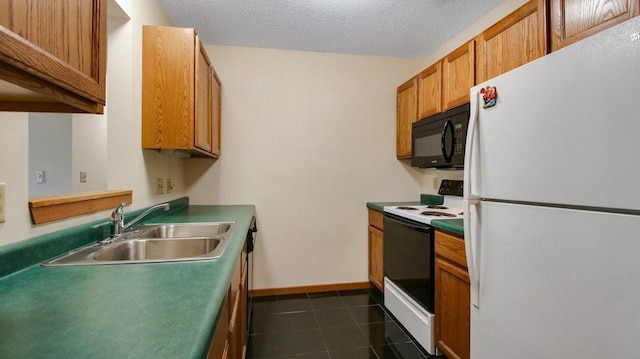 kitchen with electric stove, freestanding refrigerator, a sink, black microwave, and dark tile patterned floors