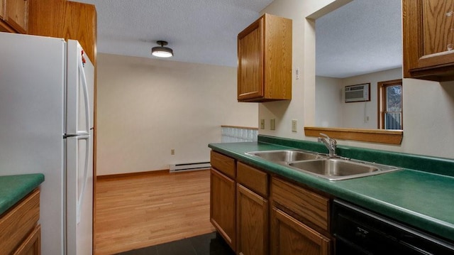 kitchen featuring brown cabinetry, dishwasher, a baseboard radiator, freestanding refrigerator, and a sink