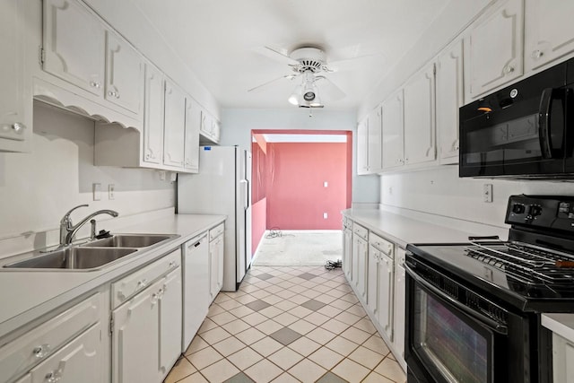 kitchen with black appliances, a sink, light countertops, and white cabinets