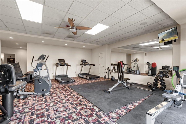 exercise room featuring carpet, recessed lighting, ceiling fan, a drop ceiling, and baseboards