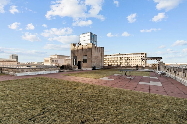 view of community with a yard, fence, and a patio