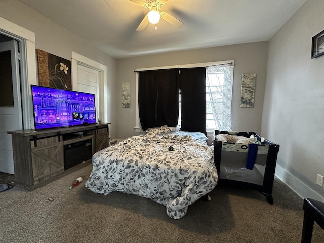 carpeted bedroom with ceiling fan and baseboards