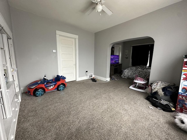 bedroom featuring arched walkways, ceiling fan, carpet, and baseboards