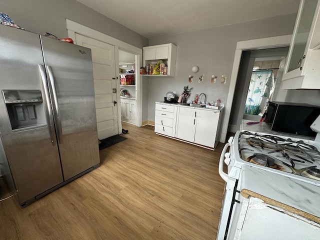 kitchen featuring light wood-style floors, white cabinetry, white range with gas cooktop, and stainless steel fridge with ice dispenser