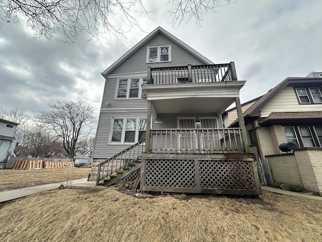 rear view of property with a balcony and a porch