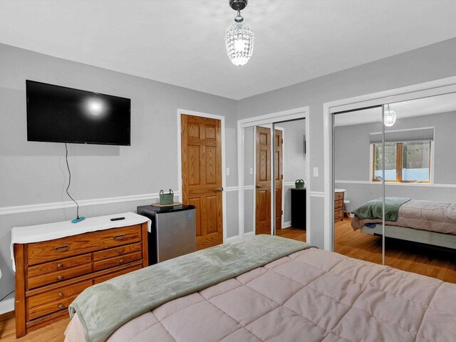 605 S Adams Ave, Marshfield, WI 54449 - bedroom featuring freestanding refrigerator, light wood-style flooring, and two closets