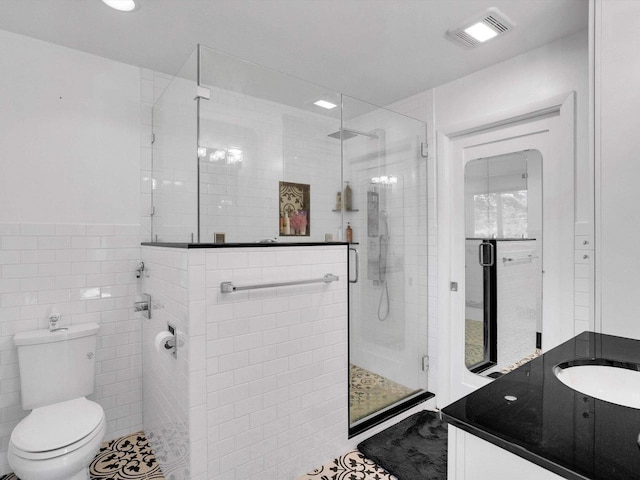 605 S Adams Ave, Marshfield, WI 54449 - full bathroom featuring visible vents, toilet, vanity, a shower stall, and tile walls