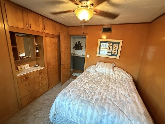 bedroom with carpet floors, ornamental molding, and a ceiling fan