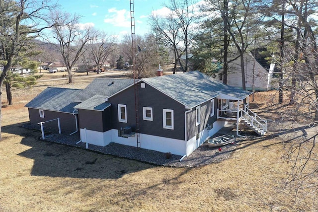 view of home's exterior featuring a shingled roof, central AC unit, a lawn, a chimney, and stairs