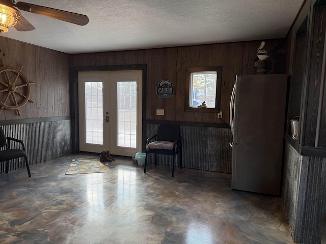 foyer entrance featuring concrete flooring, french doors, and a textured ceiling