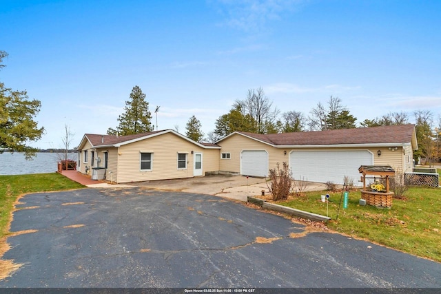 single story home featuring driveway, an attached garage, fence, and a front lawn