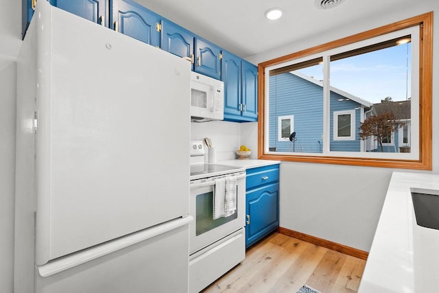 kitchen featuring white appliances, baseboards, light wood finished floors, and blue cabinetry