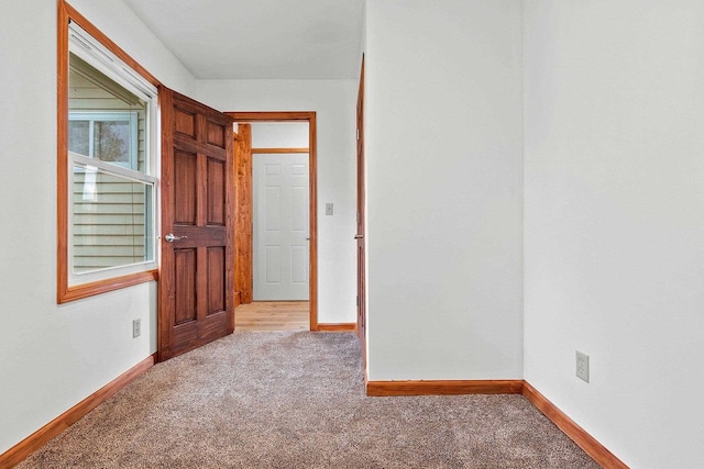 unfurnished room featuring carpet floors and baseboards